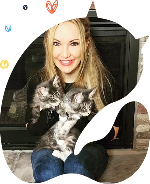 A woman sitting and holding two small grey tabby kittens.